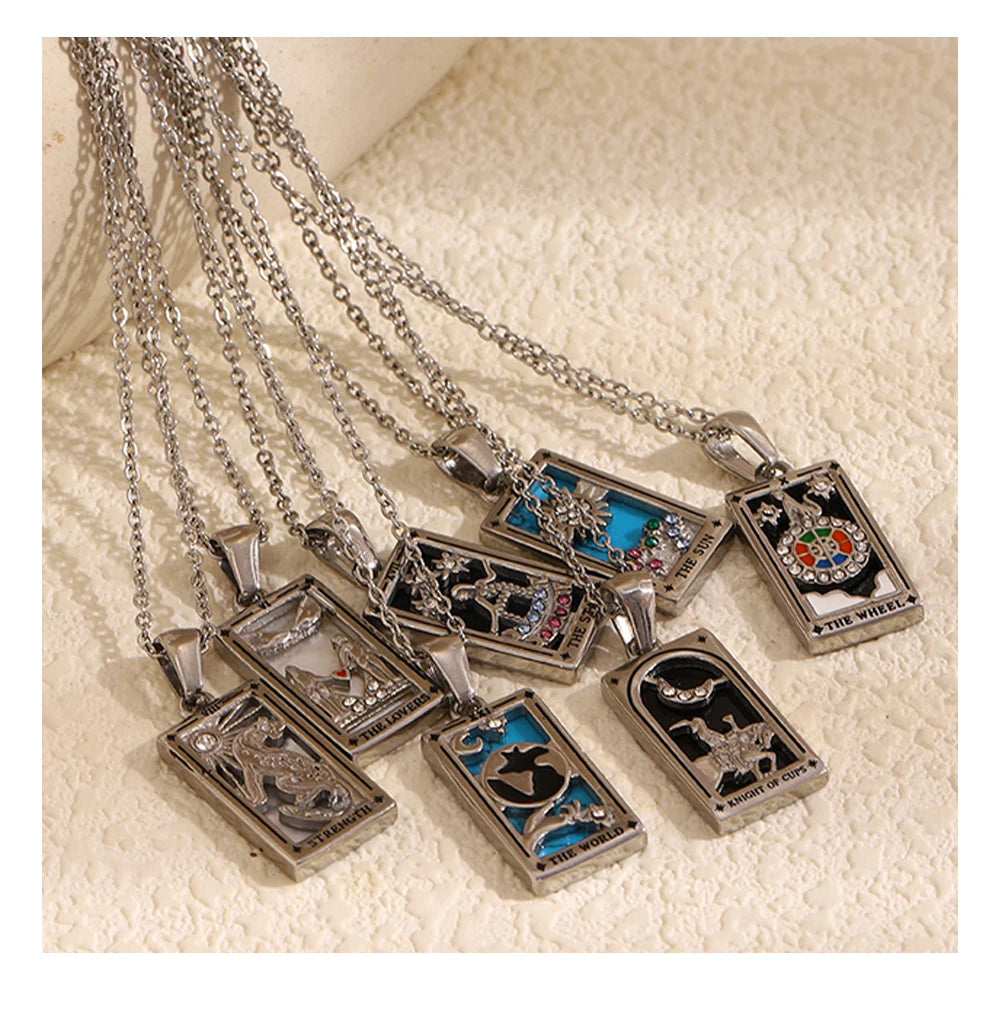 Collection of tarot card pendant necklaces on a textured surface