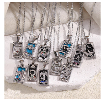 Collection of tarot card pendants on silver chains displayed on a textured white surface.