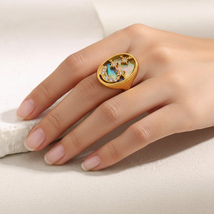 Gold ring with a colorful gemstone and small diamonds on a light background