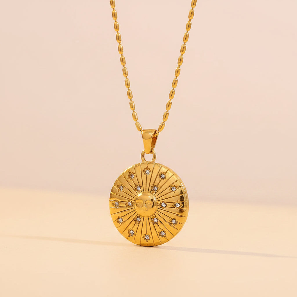 Gold necklace with a circular pendant on a beige background