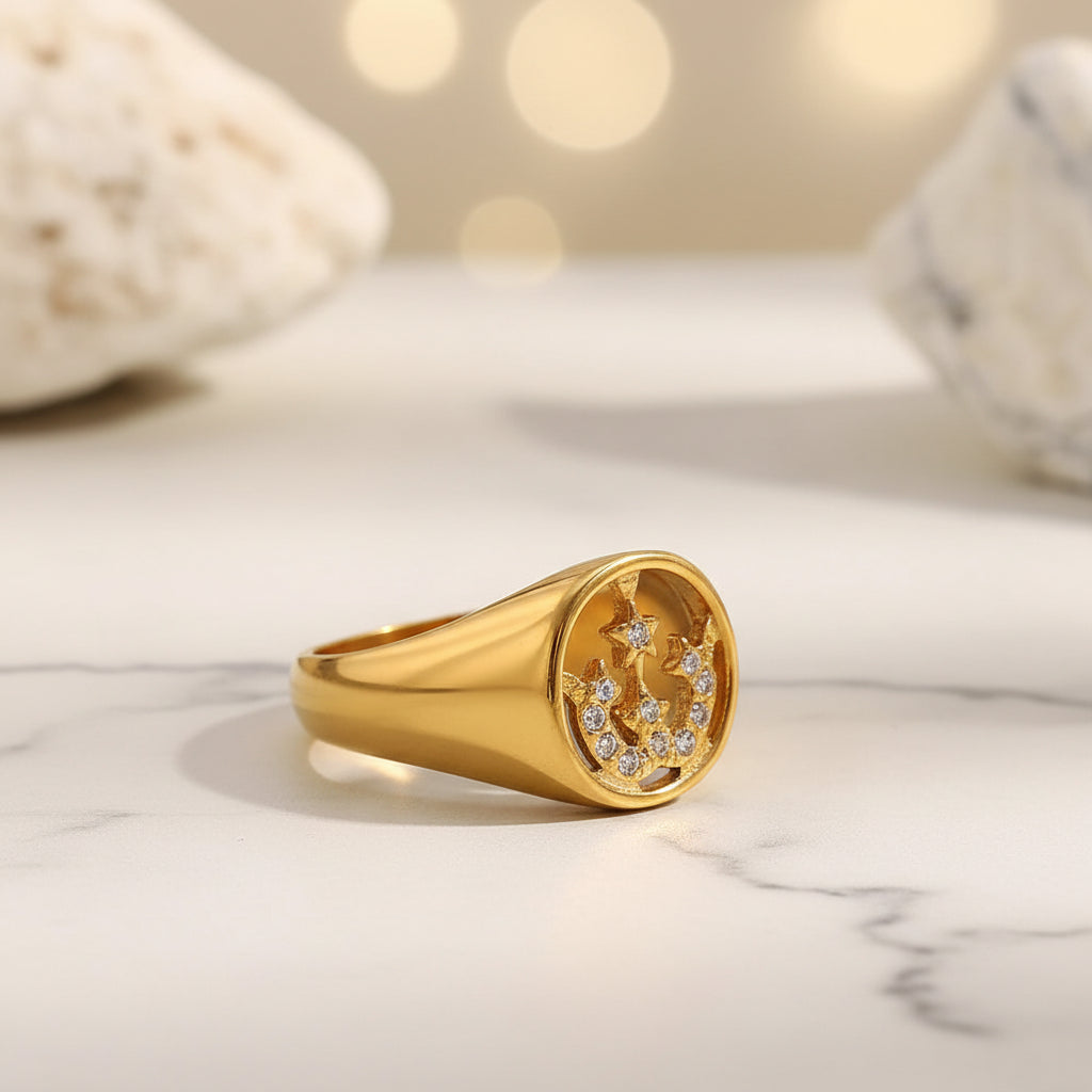 Gold ring with embedded stones on a textured surface