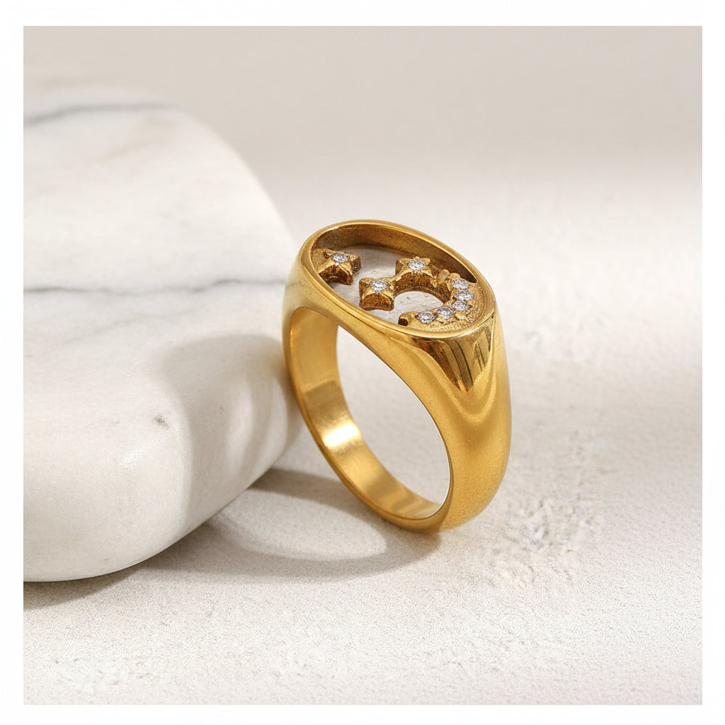 Gold ring with embedded stones on a marble surface