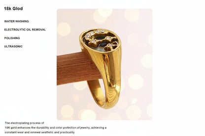 Gold ring with gemstones on a wooden stand against a light pink background