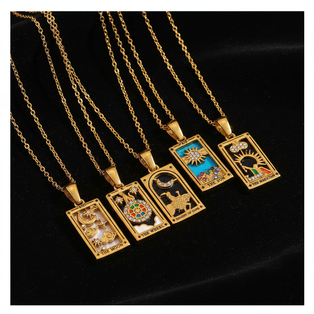Gold necklaces with tarot card pendants on a textured white surface