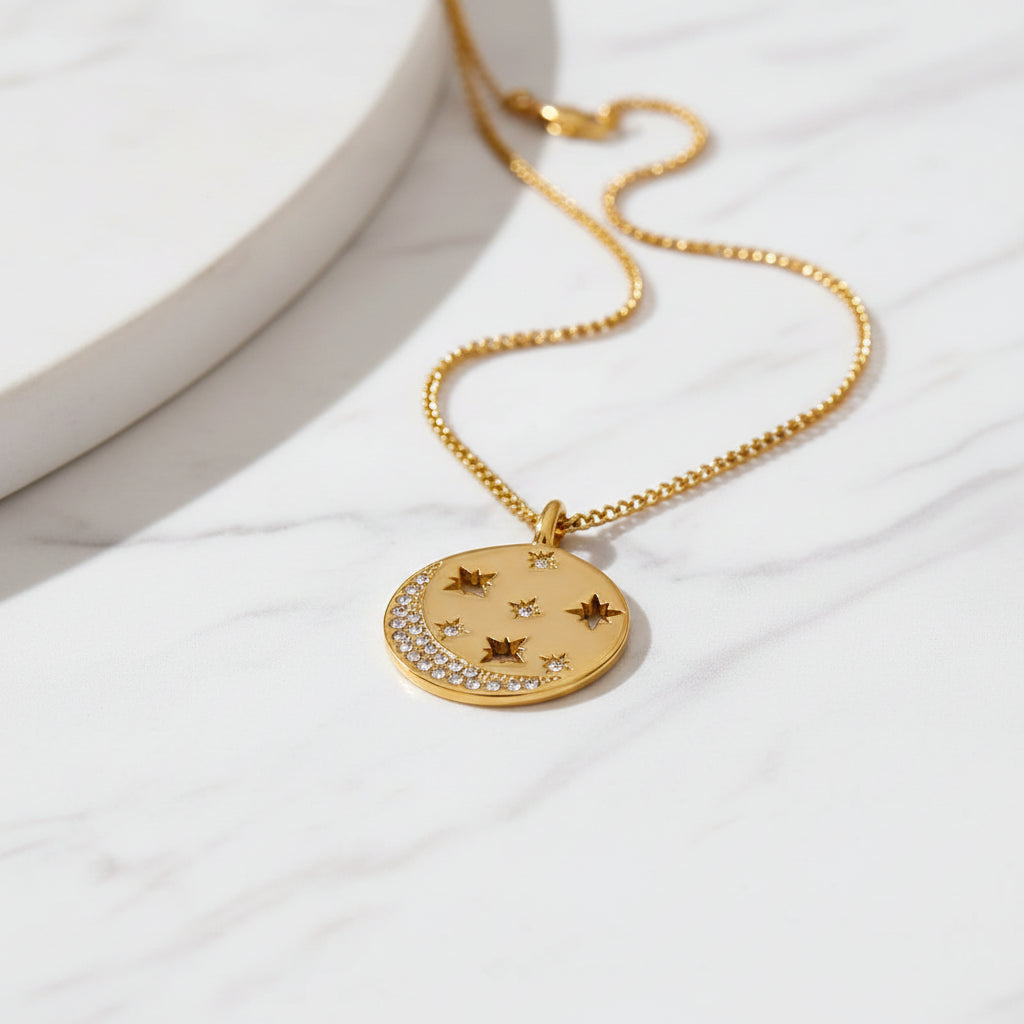 Gold necklace with star-shaped pendant on a textured beige background
