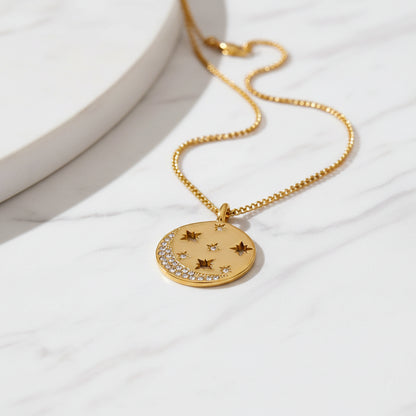 Gold necklace with star-shaped pendant on a textured beige background